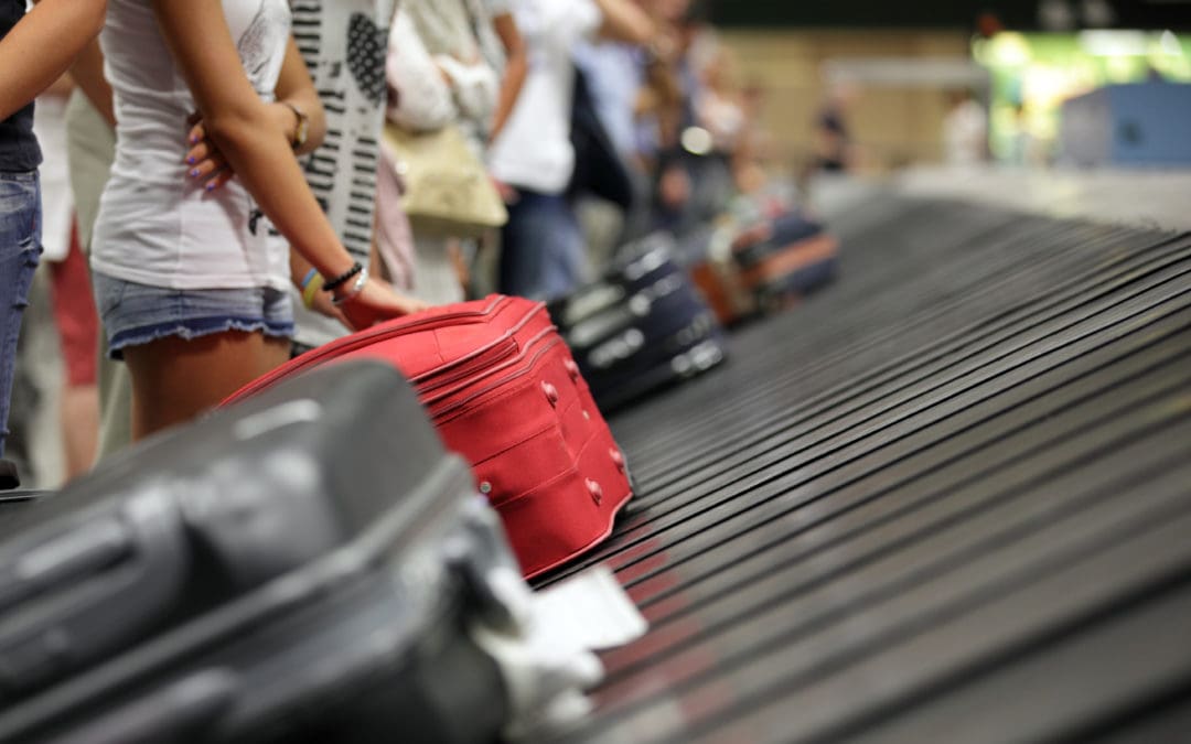 Suitcase on luggage conveyor belt in the baggage claim at airport