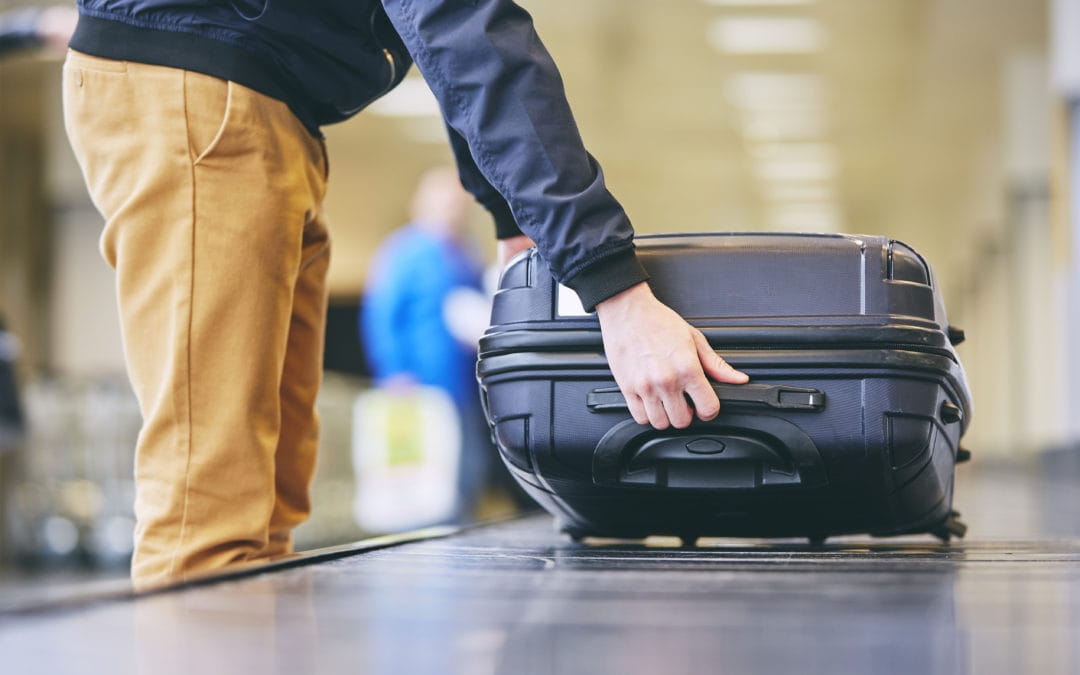 man-retrieving-baggage-carousel-airport